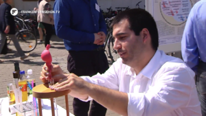 photo of Francisco Bioucas demonstrating the measurement of viscosity with a capillary viscometer