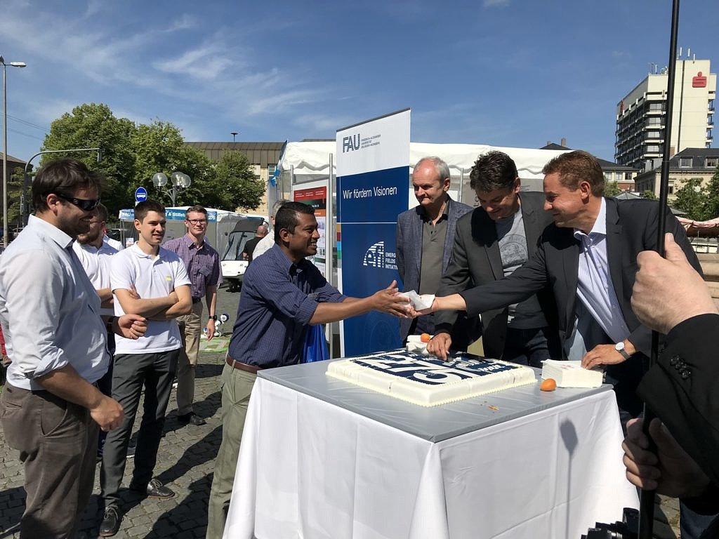 photo of Ubaya Higgoda receiving a piece of the FAU birthday torte