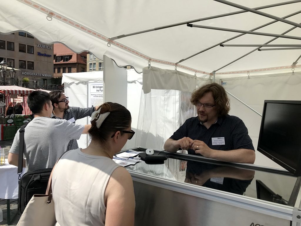 photo of Pouria Zangi explaining the posters while Michael Rausch discusses the DLS setup