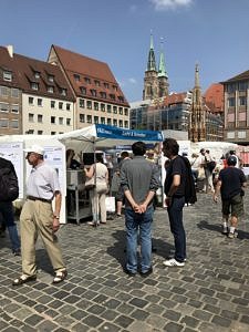 photo of Pouria Zangi discussing the AOT-TP market stand with the president of FAU, Prof. Hornegger