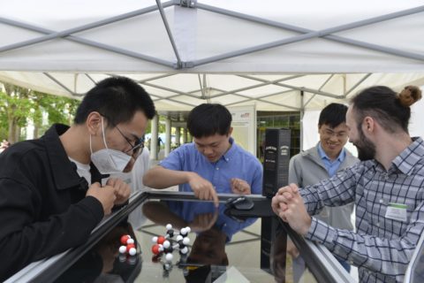 Taotao Zhan, Junwei Cui, and Maximilian Piszko showing the DLS setup to some interested guests