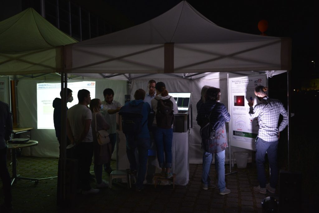 Photo of Francisco Bioucas, Julius Jander, and Maximilian Piszko explaining the DLS experiment and the results.