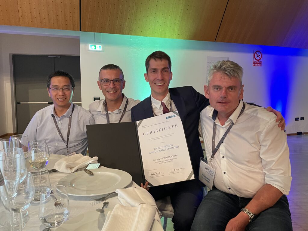 Photo shows Jiangtao Wu, Fernando Caetano and Andreas P. Fröba celebrating with Thomas M. Koller who is showing the award certificate.