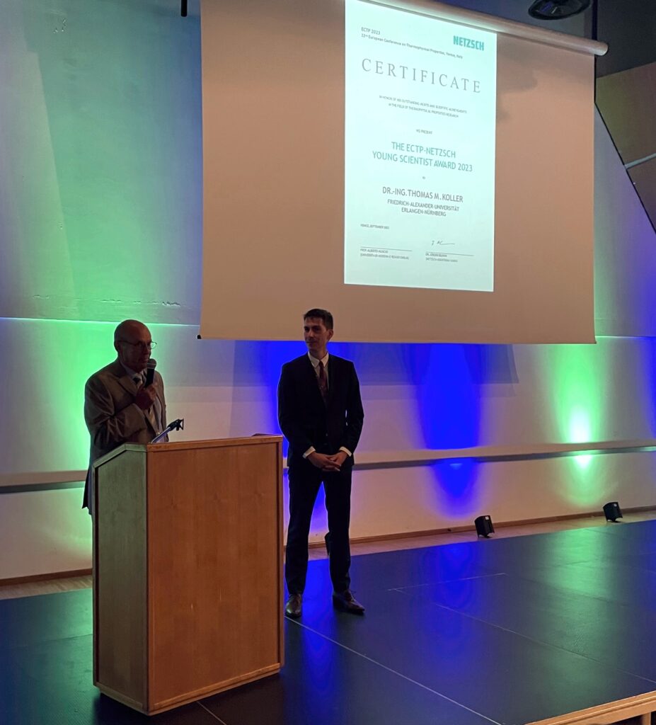 Photo showing Sir William A. Wakeham during his laudation of Thomas M. Koller who is standing next to him on the stage.