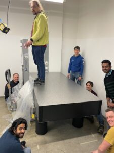 Photo showing several members of AOT-TP during the installation of a new optical table.